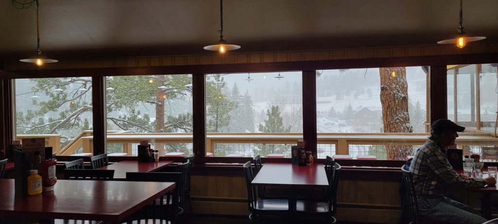 Windows overlooking snowy trees at Lariat Lodge Brewery in Evergreen. Photo by: Dev Adams